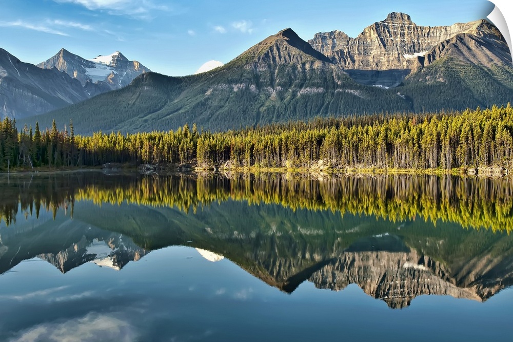 Magical mountain reflection of Canadian Rockies in Herbert Lake on peaceful morning in Banff National Park.