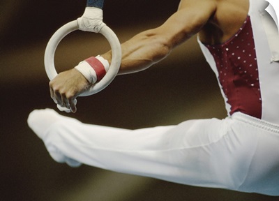 Male gymnast performing on rings, close-up