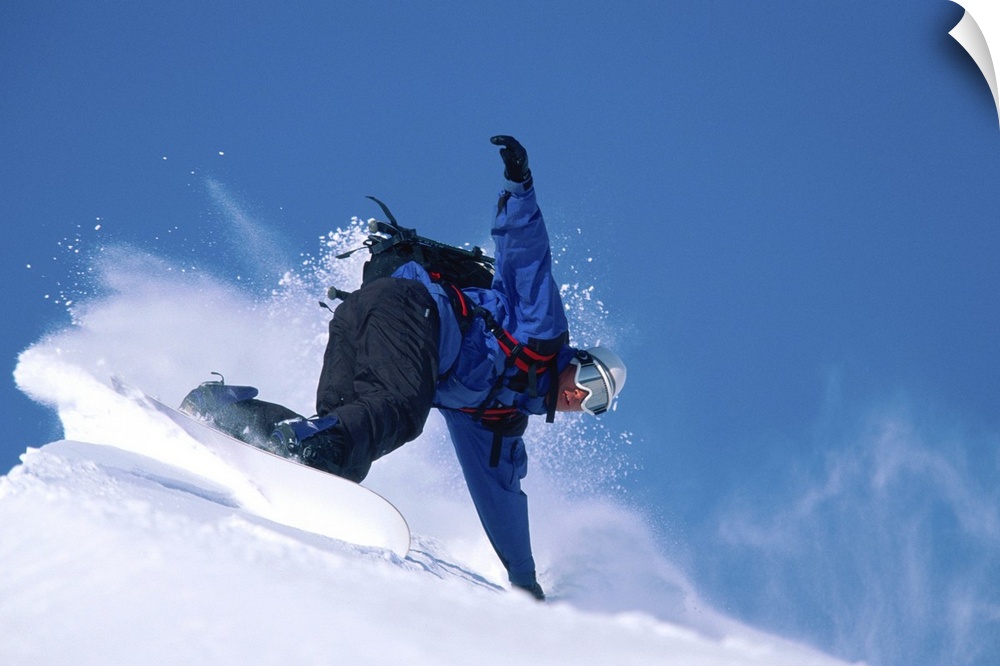 Male snowboarder leaning into slope, low angle view