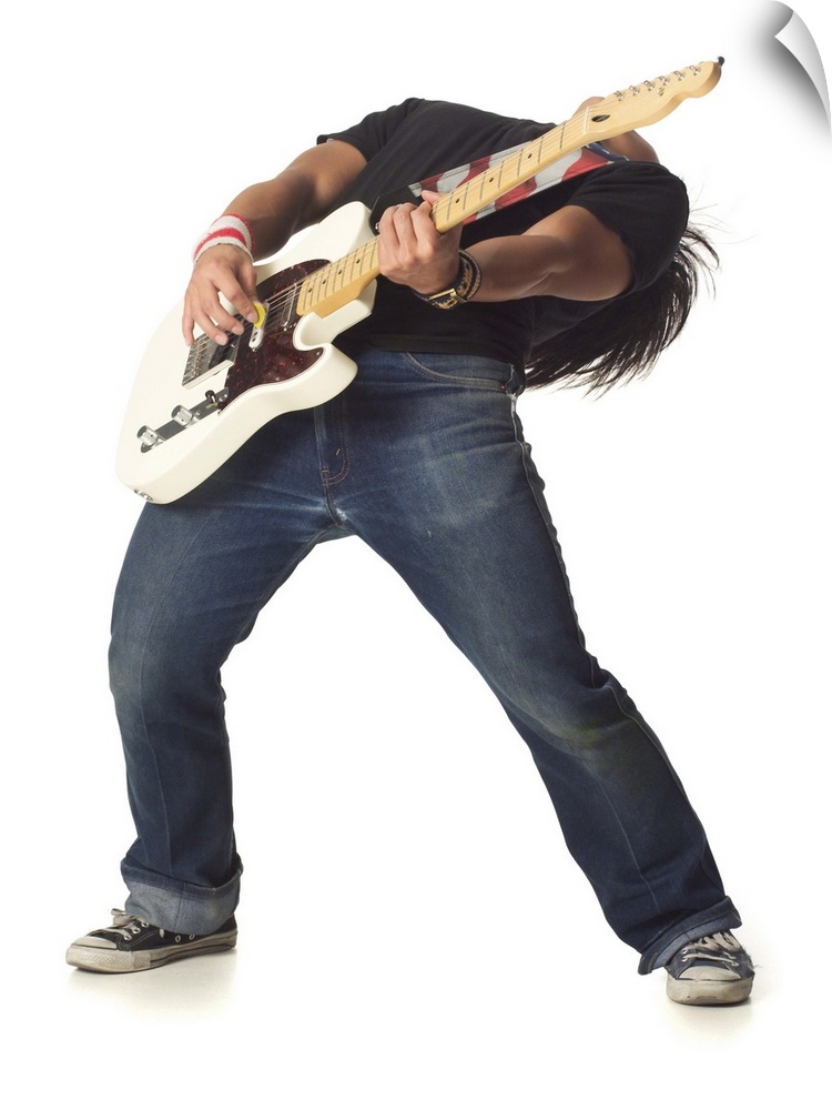an asian male teen in jeans and a black shirt leans back while playing an electric guitar