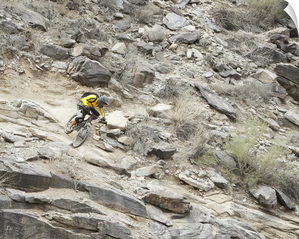 Man mountain biking down rocky mountain slope, elevated view