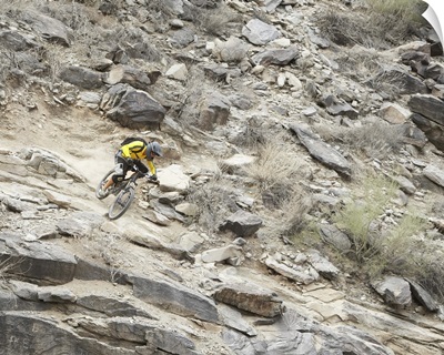 Man mountain biking down rocky mountain slope, elevated view