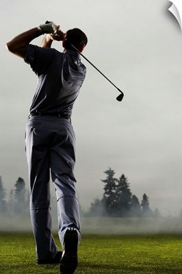 Man playing golf, rear view