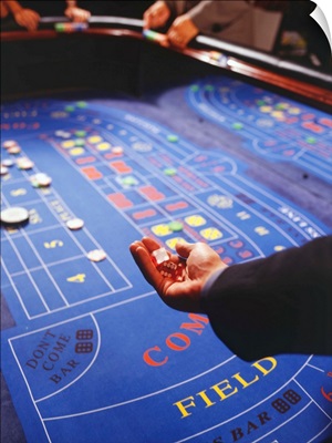 Man shaking dice during game of craps in casino