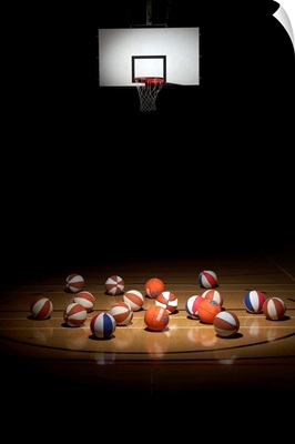 Many basketballs resting on the floor