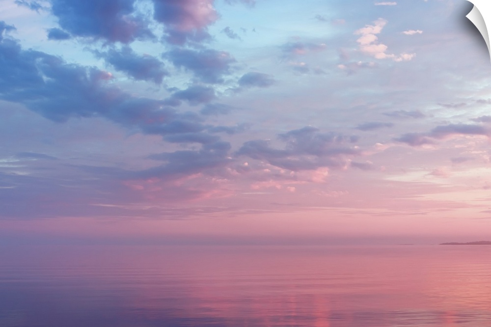 Misty lilac seascape with pink and blue clouds over the water of Lake Onega, Russia, Republic of Karelia.