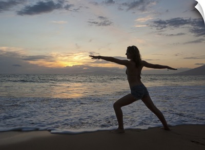Mixed race woman practicing yoga on beach