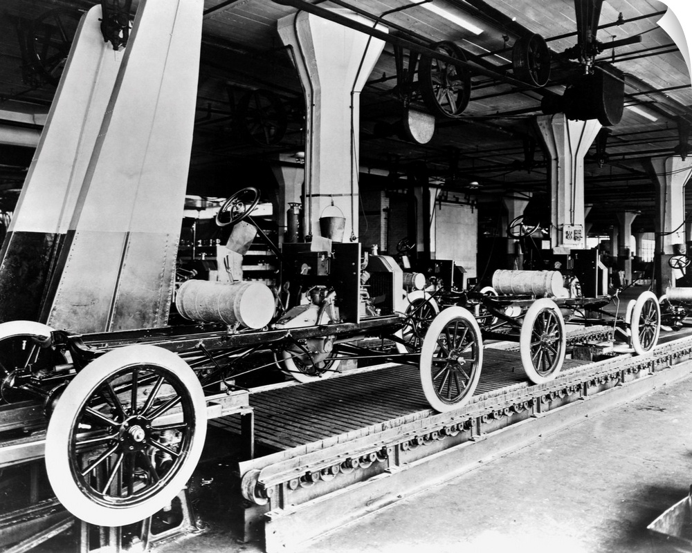 A line of Model T automobiles await further assembly. The Highland Park Ford Plant in Michigan is considered to be the bir...