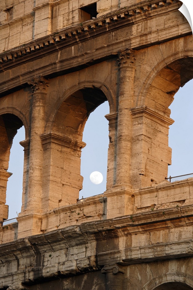 Vertical photo on canvas of the moon shining through an opening of one of the arches in the Colosseum.