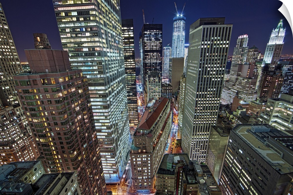 Tall industrial buildings in New York City are illuminated in the evening by office lights from late-night businesspeople.