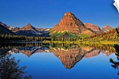 Painted Teepee mountain, Mt. Sinopah and Lone Walker mountain reflected in Pray Lake.