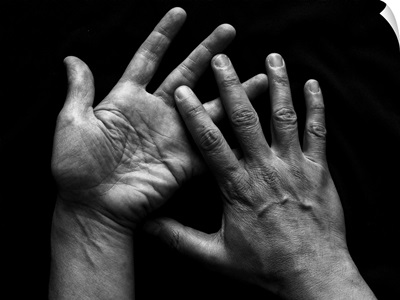 Pair of human hands on black background.