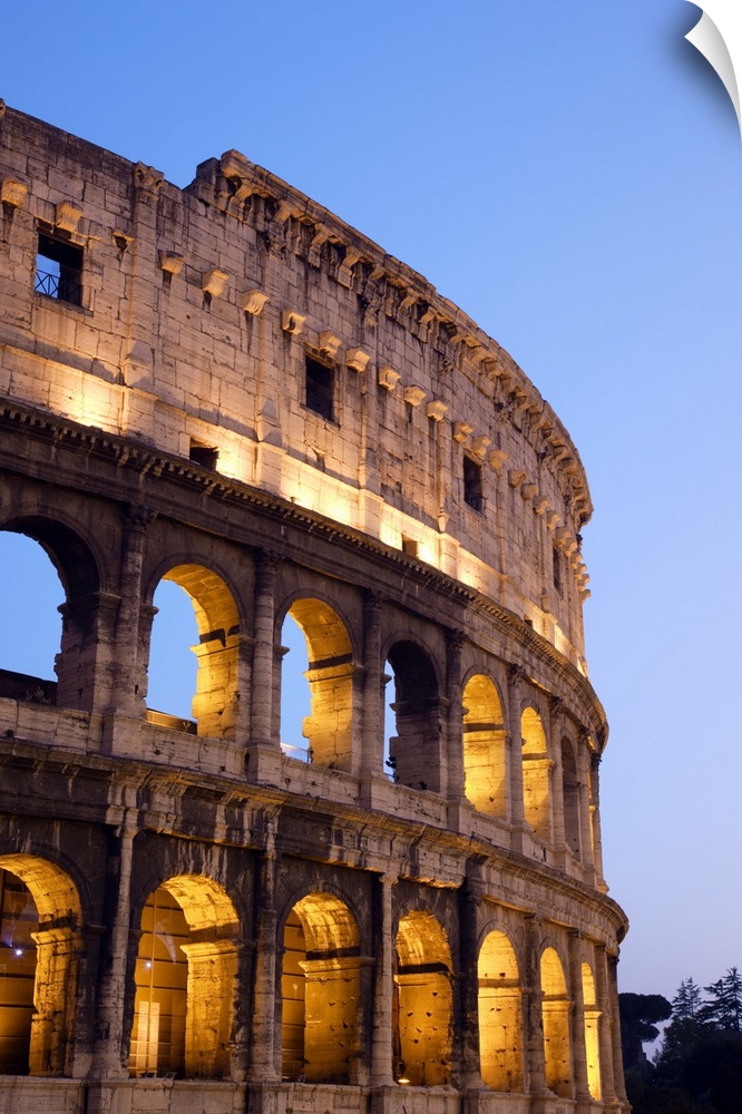 Veridical photograph of the Roman Coliseum at dusk with the lights illuminating the arched windows.
