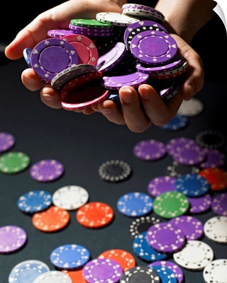 Person holding handful of gambling chips, close-up