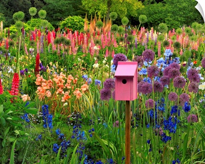Pink birdhouse in flower garden