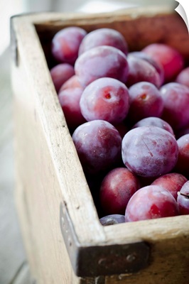 Plums in wooden box.