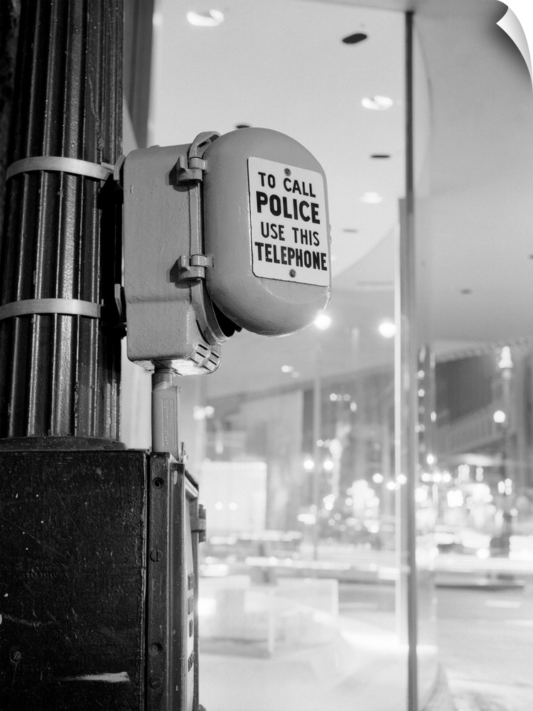 Police Call box mounted on light pole in street.