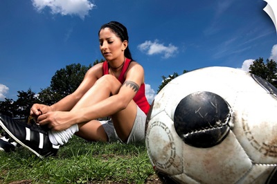 Portrait of female football player tying her shoes