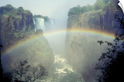 Rainbow over misty river canyon