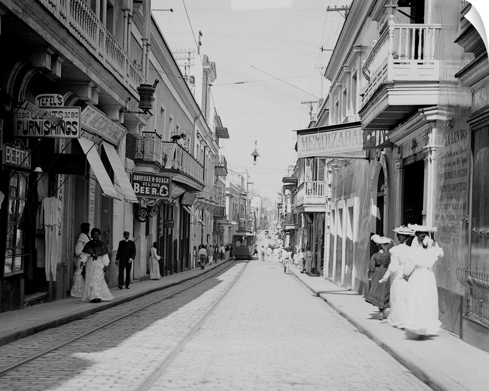 The old narrow colonial San Francisco Street in San Juan, with tracks and a street car running on one side.