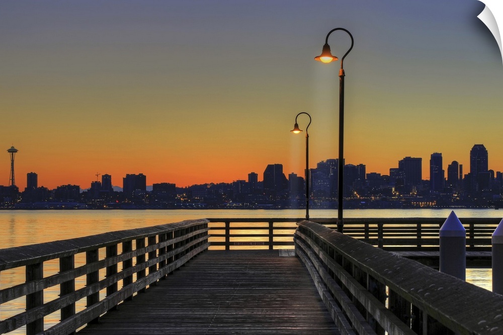 Horizontal photograph on a giant wall hanging looking down the lit Seacrest Park Fishing Pier in Alki Beach as the sun ris...
