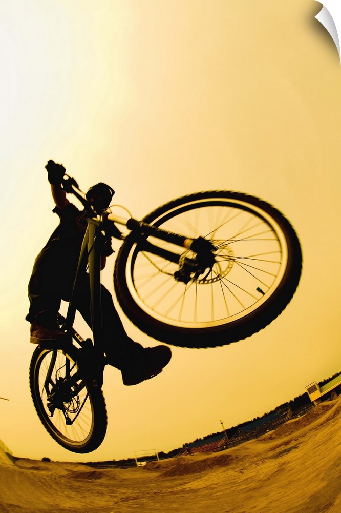 Silhouette of a cyclist against a yellow sky