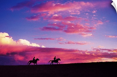 Silhouette of horseback riders at sunset in Colorado