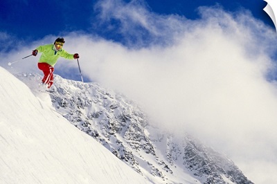 Skier flying over slope with clouds, Whistler Mount, Canada, low angle view
