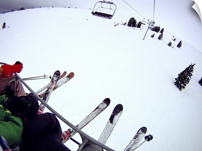 Skiers sitting on chairlift.