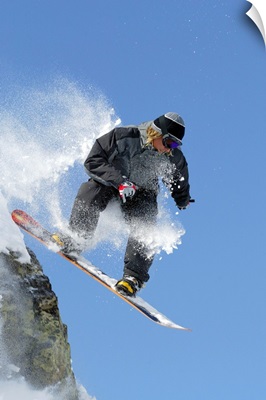 Snowboarder jumping off ledge