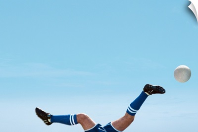 Soccer Player Upside-Down Attempting To Kick The Ball