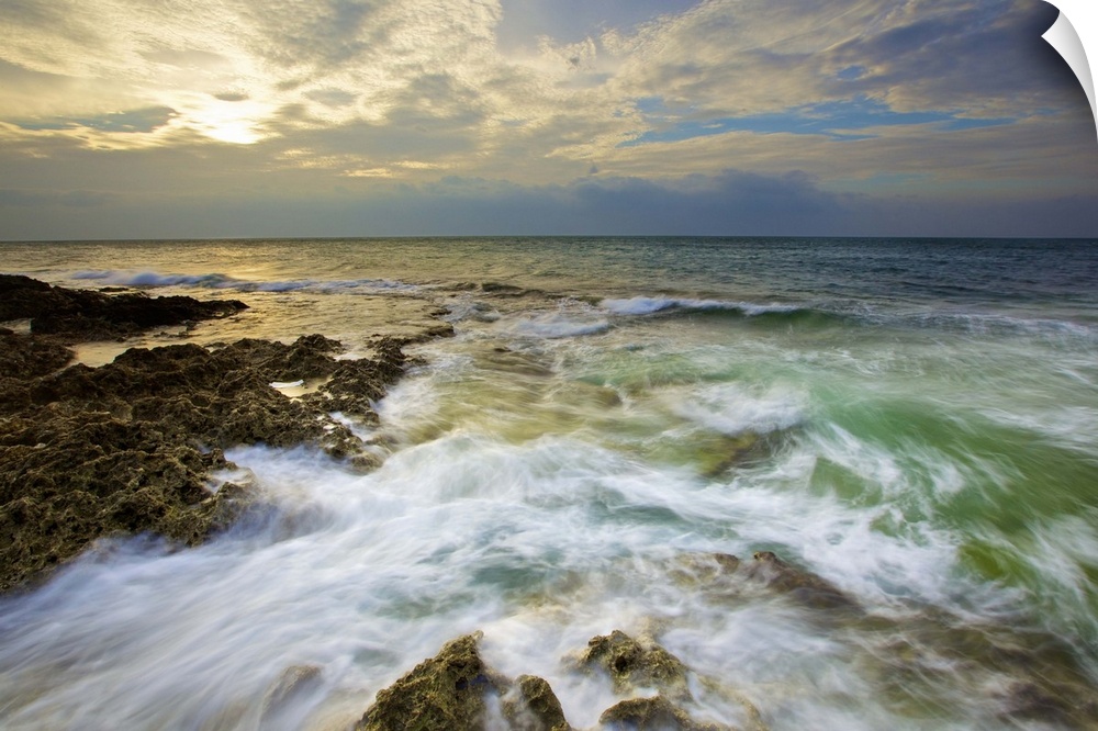 Rushing waves on coral reefs in Howan, Pingtung, after shower with setting sun shiny behind clouds.