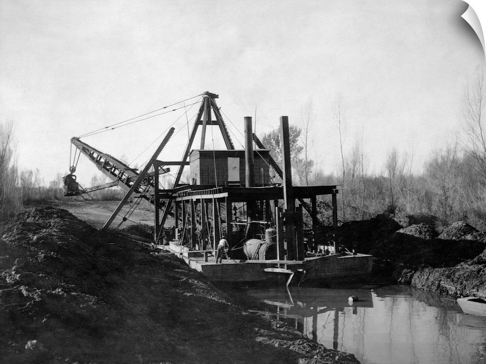 a Steam powered hydraulic dredge cut a canal through rural marsh land.