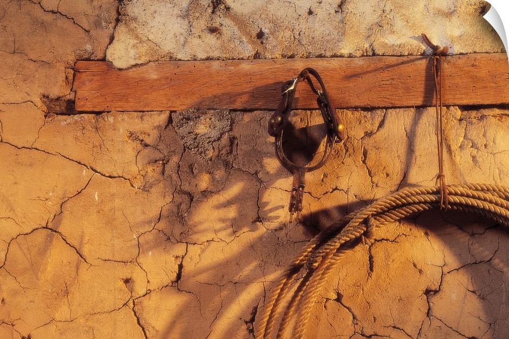 Still Life Of Spurs And Lasso Hanging On Adobe Wall