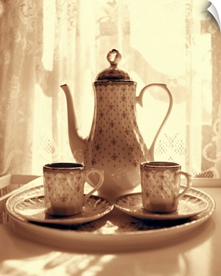 Still life of teapot and cups on tray by window