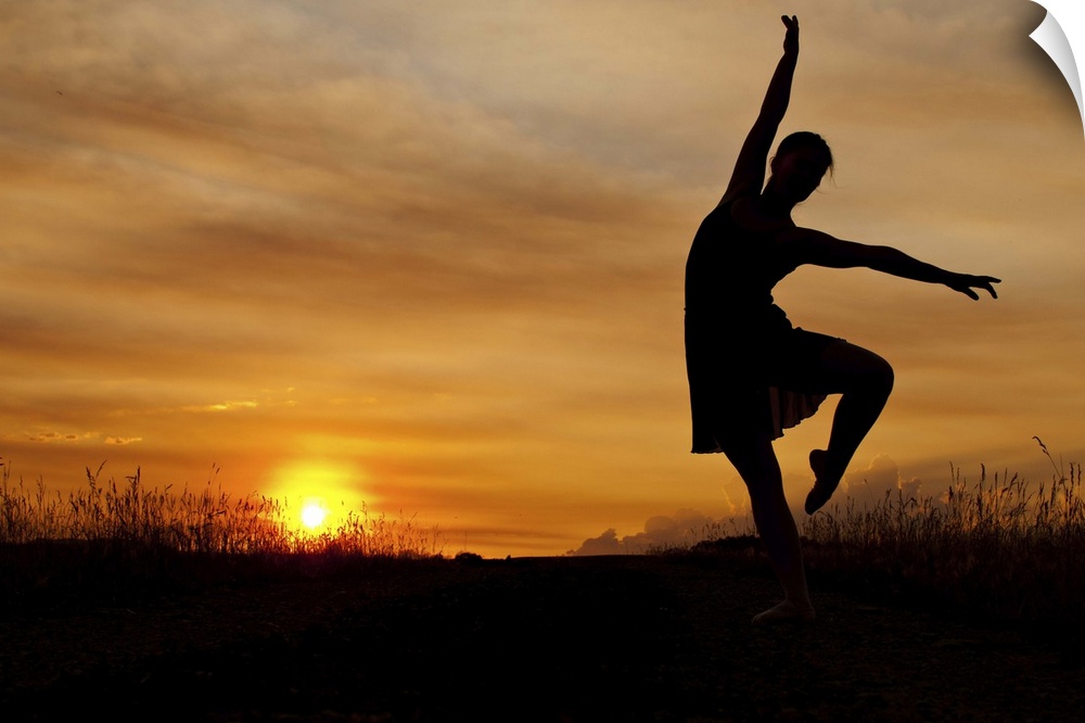 Ballerina dances as sun sets behind her.