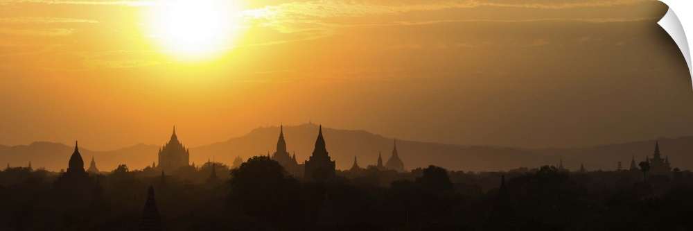 Panorama landscape showing silhouettes of pagodas, temples and trees in Bagan, Myanmar (Burma) during sunset. Bagan is a s...