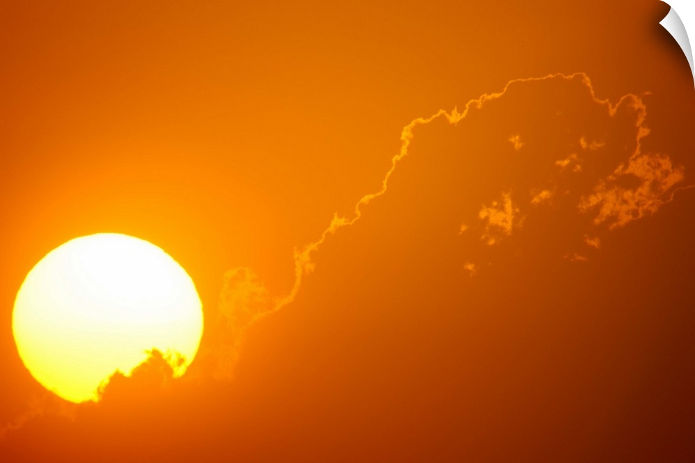 Telephoto view of the rising sun behind orange clouds, Durban, Kwazulu-Natal, South Africa