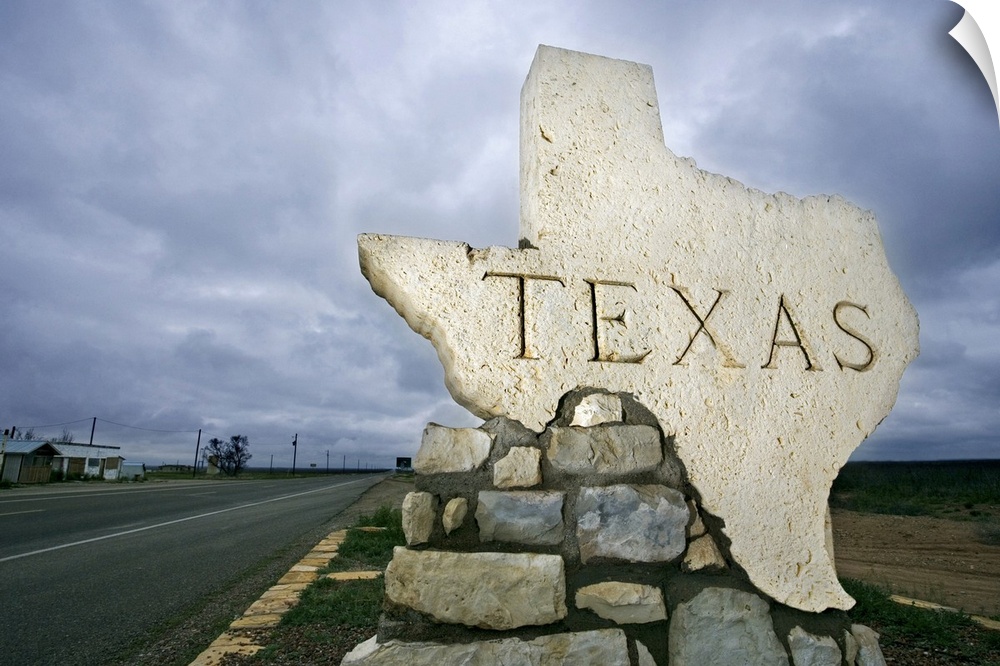Photograph of a large stone placard in the shape of Texas welcoming visitors at the state border.