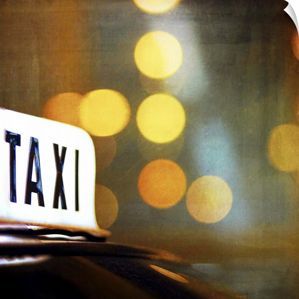 A lit taxi sign is highlighted against the city lights at night.