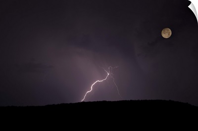 Thunderstorm, thunderbolt lightning, flash over mountain and moon at night.