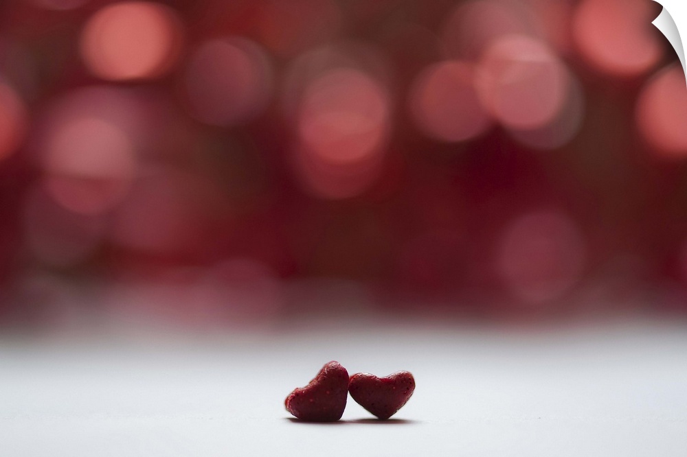 Two red hearts and red bokeh background