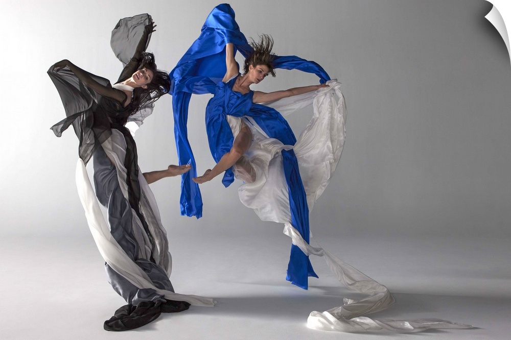 Two ballet dancers jumping together, draped in silk, fabric flows beautifully with there movement