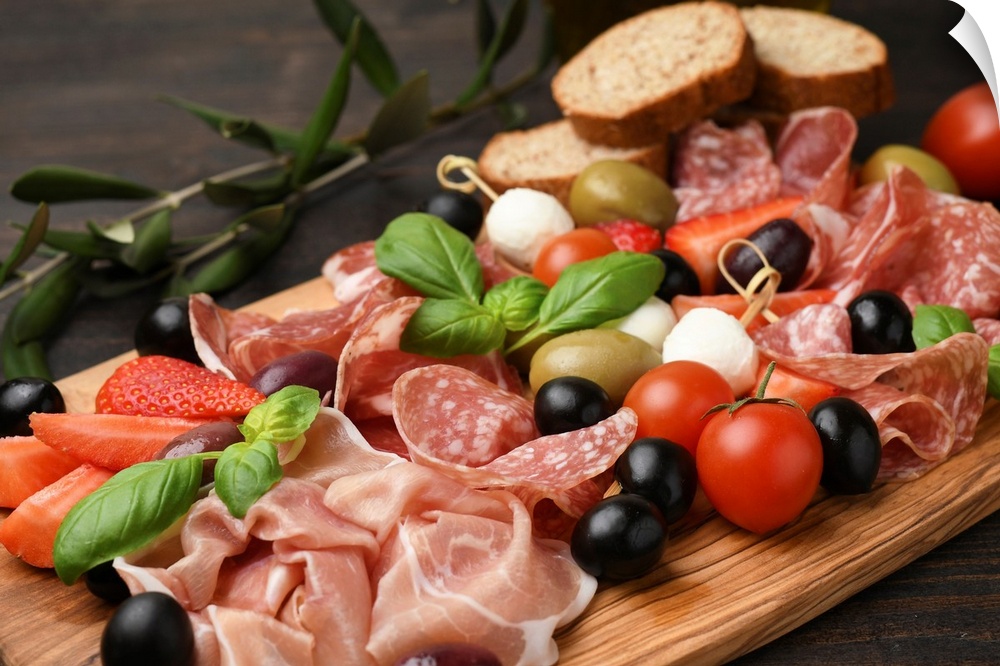 Typical antipasto in an Italian restaurant salami, ham prosciutto, with green and black olives, appetizers with mozzarella...