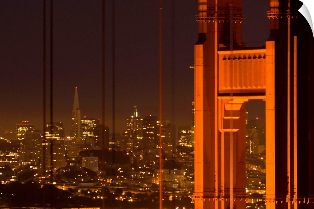 Part of the Golden Gate Bridge and the San Francisco skyline are photographed during the evening with lights illuminating ...