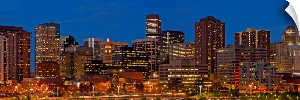 Panoramic photograph of lit up skyline under a clear sky.