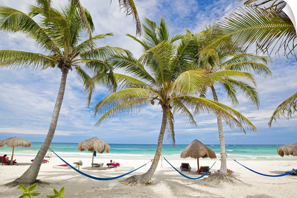 Tropical beach vacation destination with hammocks, beach chairs, and palm trees in Tulum, Mexico.