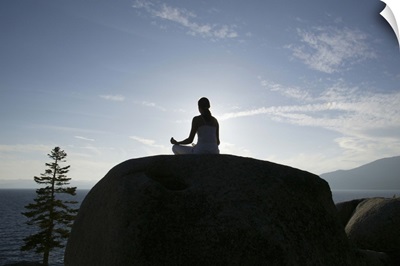 Woman meditating on rock