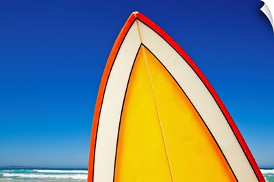 Yellow and orange retro surfboard at beach, Eyre Peninsula, South Australia.