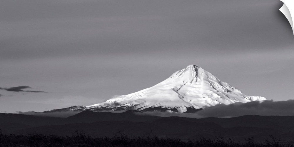A black and white photograph of a Mt. Hood under a smooth gray sky.